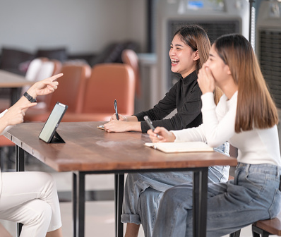 Thai women laughing with their English trainer.